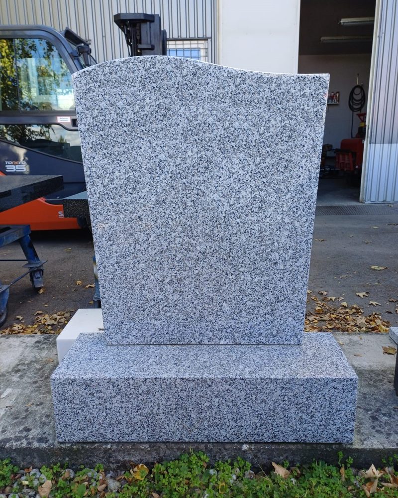 Schlichter Grabstein mit geschwungener Oberkante und Stufe aus hellgrauem französischem Tarn-Granit